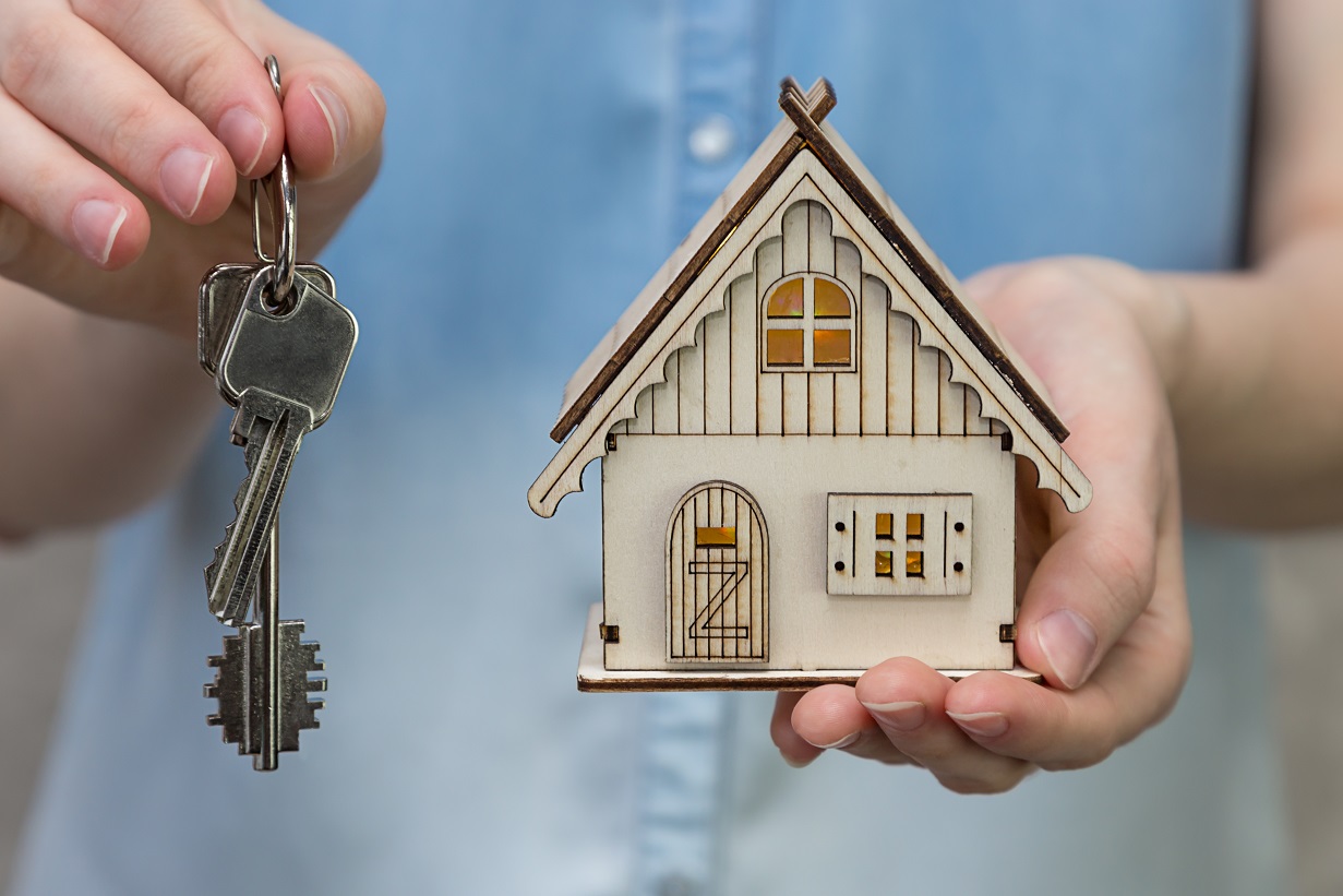 picture of small house with woman holding keys